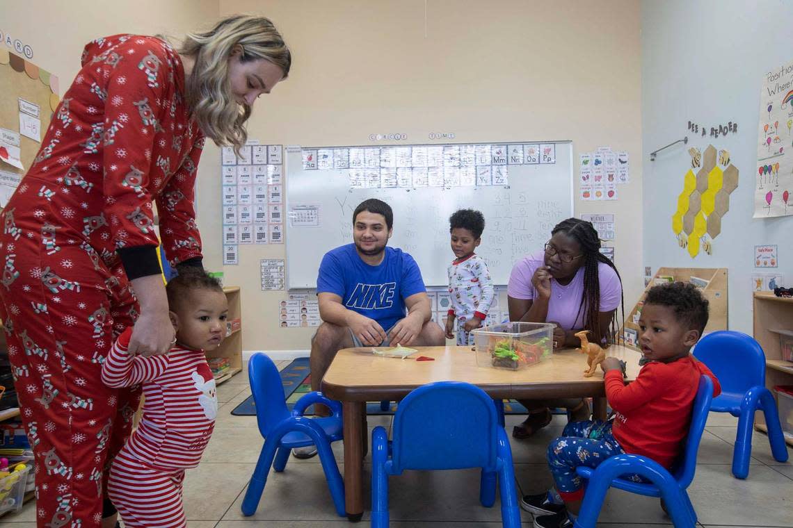 Shazira Alvarez, assistant principal, takes one-year-old Miles De Paz to his mother, Montavia De Paz, at Springview Academy of Hialeah on Friday, Dec. 23, 2022. The Thrive By 5 program in Hialeah offers help paying childcare for low-income parents. Also pictured, father Miguel De Paz, Mason De Paz, 4, and Mateo De Paz 3.