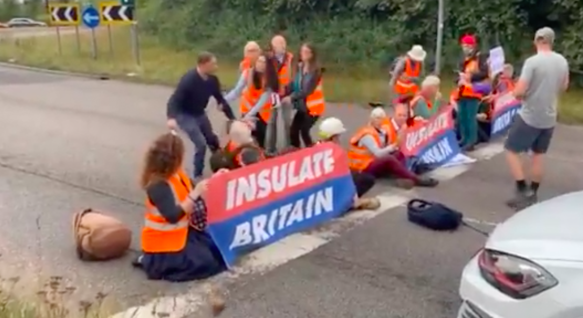 A motorist tried to drag an Insulate Britain protester off a roundabout at a junction of the M25. (LBC/Twitter)