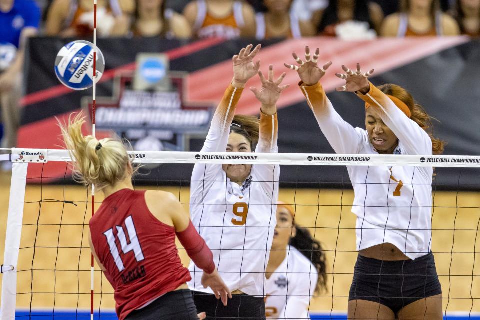 Louisville's Anna DeBeer (14) spikes the ball against Texas' Saige Ka'aha'aina-Torres (9) and Asjia O'Neal (7) in the third set during the NCAA college volleyball championship finals, Saturday, Dec. 17, 2022, in Omaha, Neb. (AP Photo/John S. Peterson)