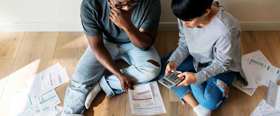 Couple seen from above with bills spread out around them