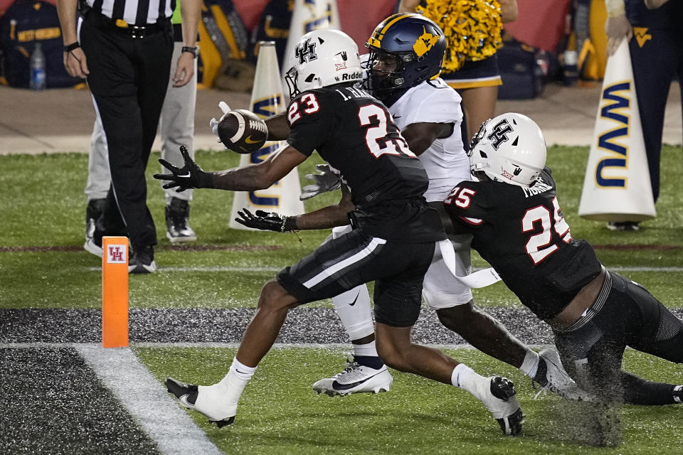 Houston defensive back Isaiah Hamilton (23) intercepts a pass intended for West Virginia running back Jaylen Anderson (0) during the third quarter of an NCAA college football game Thursday, Oct. 12, 2023, in Houston. (AP Photo/Kevin M. Cox)