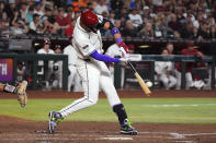 Arizona Diamondbacks' Lourdes Gurriel Jr. connects for a run-scoring single against the Colorado Rockies during the third inning of a baseball game Thursday, March 28, 2024, in Phoenix. (AP Photo/Ross D. Franklin)