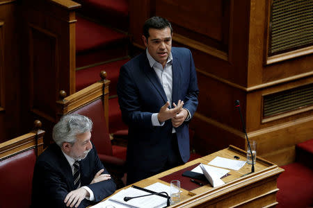 Greek Prime Minister Alexis Tsipras (R) addresses lawmakers before a parliamentary vote of a law that allows citizens to declare a gender change on official documents in Athens, Greece October 10, 2017. REUTERS/Costas Baltas