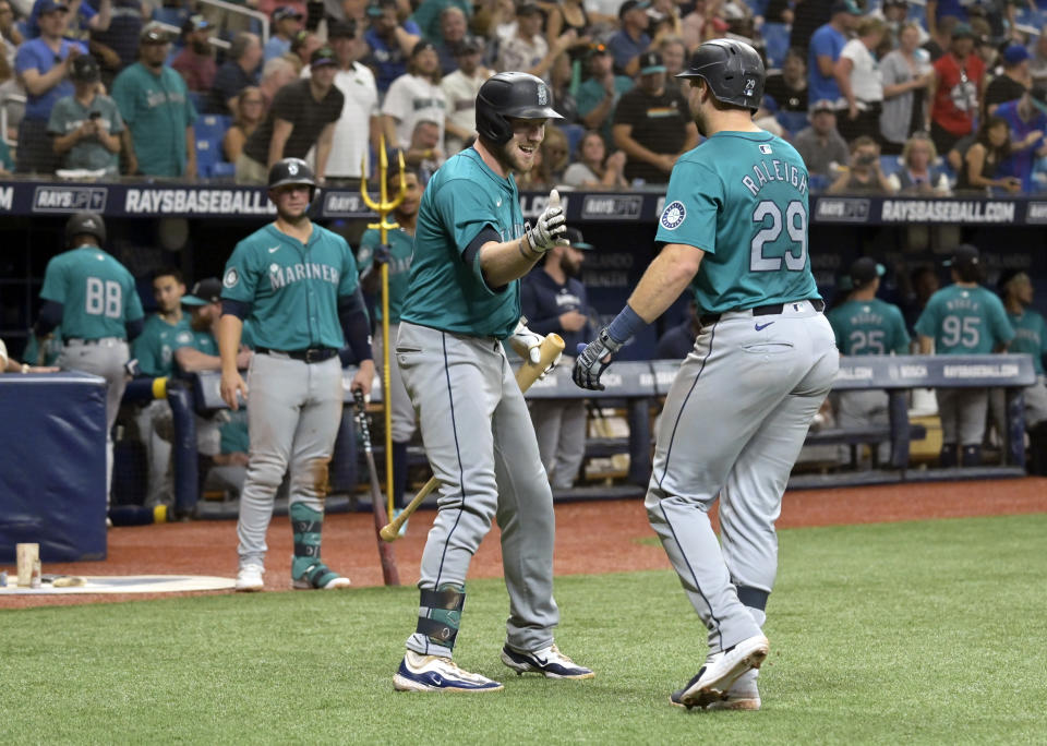 Seattle Mariners on-deck batter Luke Raley, center left, greets Cal Raleigh (29) after Raleigh's solo home run off Tampa Bay Rays starter Taj Bradley during the fourth inning of a baseball game Monday, June 24, 2024, in St. Petersburg, Fla. (AP Photo/Steve Nesius)