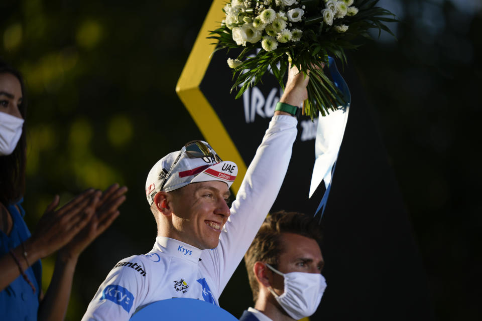 Slovenia's Tadej Pogacar, wearing the best young rider's white jersey, celebrates on the podium after the twenty-first stage of the Tour de France cycling race over 116 kilometers (72 miles) with start in Paris la Defense Arena and finish on the Champs Elysees in Paris, France, Sunday, July 24, 2022. (AP Photo/Daniel Cole)