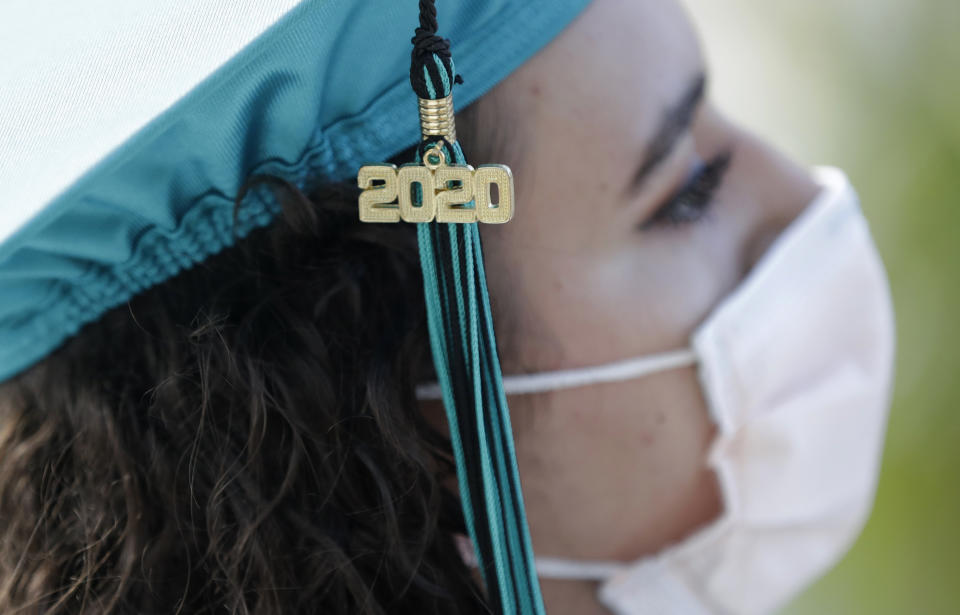 FILE - In this June 23, 2020, file photo, Valedictorian Sierra Morgado's graduation tassel has "2020" on it as she listens during a graduation ceremony for the senior class of Chambers High School at Homestead-Miami Speedway in Homestead, Fla. (AP Photo/Wilfredo Lee)