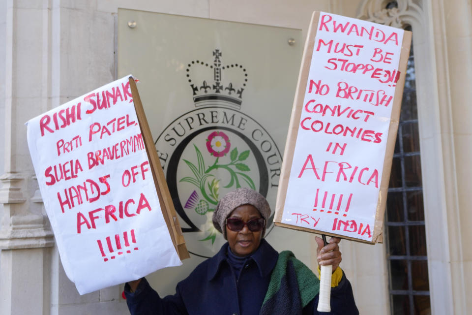 A protester stands outside the Supreme Court in London, Wednesday, Nov. 15, 2023. Britain's highest court is set to rule Wednesday, Nov. 15 on whether the government's plan to send asylum-seekers to Rwanda is legal, delivering a boost or a blow to a contentious central policy of Prime Minister Rishi Sunak's administration. Five justices on the U.K. Supreme Court will deliver judgment in the government's attempt to overturn a lower court ruling that blocked deportations. (AP Photo/Kirsty Wigglesworth)