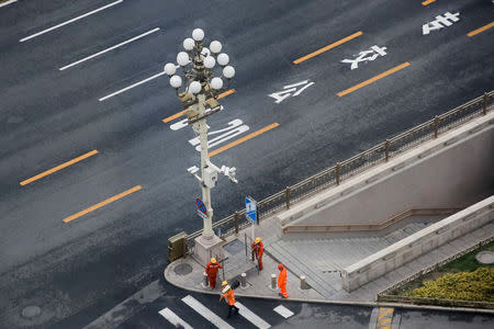 Workers walk in Chang'an Avenue near Tiananmen Square in Beijing, China April 9, 2019. REUTERS/Thomas Peter