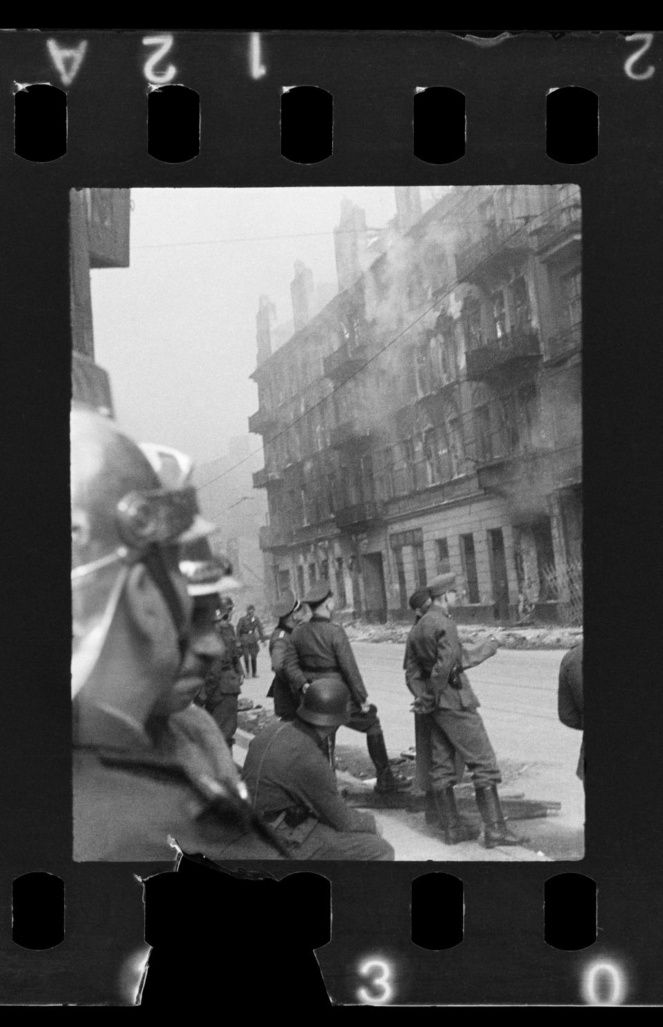 This handout negative dated on April 20, 1943, and taken by Polish firefighter Zbigniew Leszek Grzywaczewski negative shows houses that were abandoned by the Jewish population as they were evacuated being set on fire during the uprising of the Warsaw ghetto in 1943, Poland. On Wednesday, Jan. 18, 2023, Warsaw’s Jewish history museum presented a group of photographs taken in secret during the Warsaw Ghetto Uprising of 1943, some of which have never been seen before, that were recently discovered in a family collection. (Z. L. Grzywaczewski/courtesy of Maciej Grzywaczewski/POLIN Museum via AP)