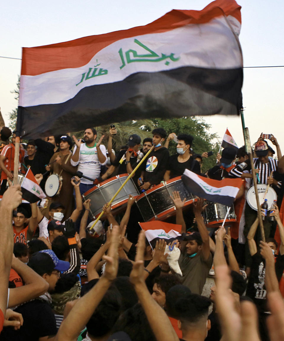 Anti-government protesters wave national flags during a demonstration in Baghdad, Iraq, Saturday, Oct. 26, 2019. Iraqi protesters converged on a central square in the capital Baghdad on Saturday as security forces erected blast walls to prevent them from reaching a heavily fortified government area after a day of violence that killed scores. (AP Photo/Khalid Mohammed)