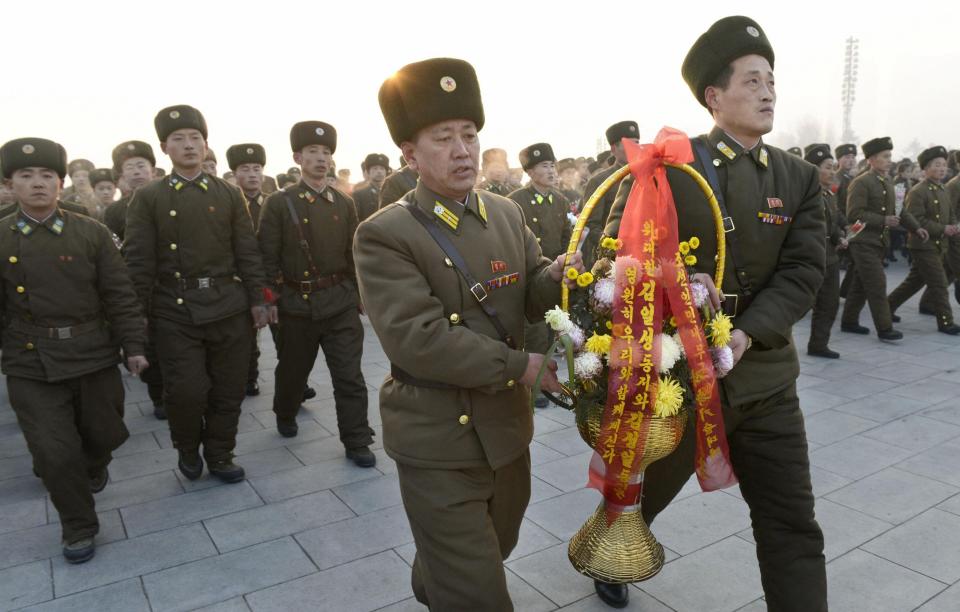 North Korean soldiers offer flowers to bronze statues of North Korea's late founder Kim Il Sung and late leader Kim Jong Il at Mansudae in Pyongyang