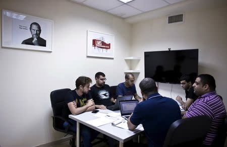 Firas Jabbour (C), founder and CEO of start-up Edunation, a social-learning platform, meets with his team at their offices in Nazareth, Israel June 3, 2015. REUTERS/Nir Elias/File Photo