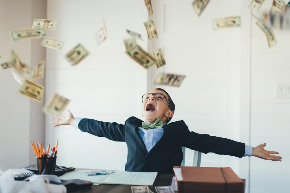 A child celebrates as cash rains down.