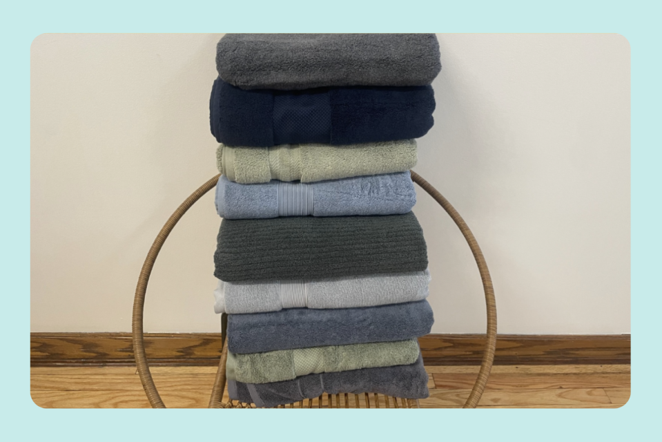 A stack of plush bath towels is shown for Yahoo's Best Plush Bath Towel guide.