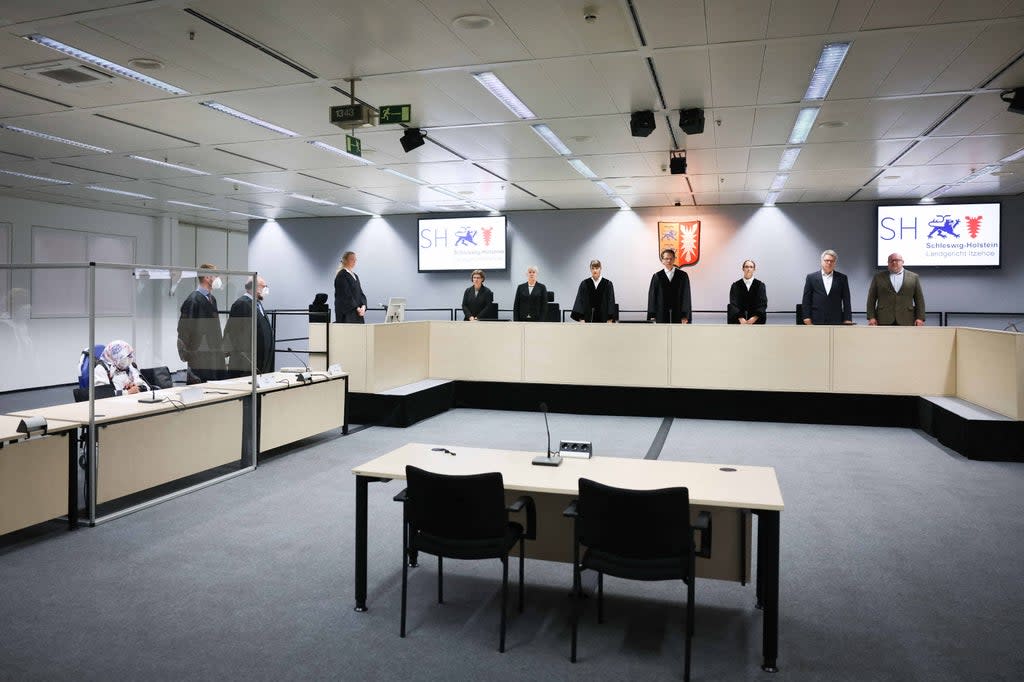 File: 96-year-old defendant Irmgard F. (L), a former secretary for the SS commander of the Stutthof concentration camp, sits in the courtroom next to her lawyers Niklas Weber (2ndL) and Wolf Molkentin (3rdL), as the presiding judge Dominik Gross (4thR) and his team stand at the start of her trial   at the courtroom in Itzehoe, northern Germany, on 19 October 2021 (POOL/AFP via Getty Images)