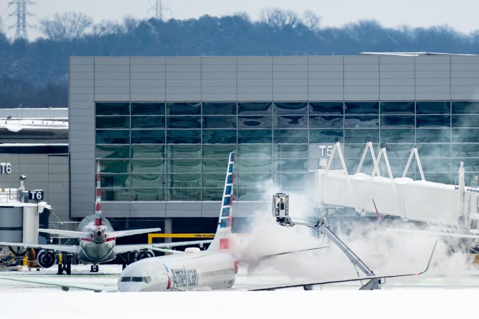 An American Airlines flight is de-iced at Nashville International Airport in Nashville, Tenn., Tuesday, Jan. 16, 2024. Over 100 flights were delayed or canceled Monday due to the winter weather.