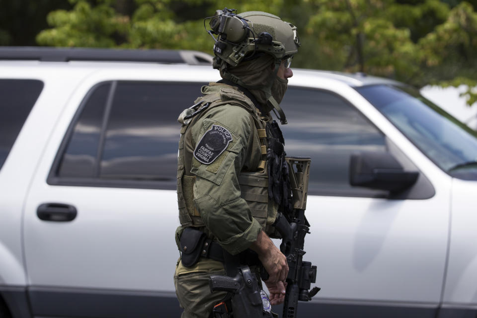A Fairfax Police tactical officer walks near the building that houses Gannett and USA Today, Wednesday, Aug. 7, 2019, in McLean, Va. (AP Photo/Alex Brandon)