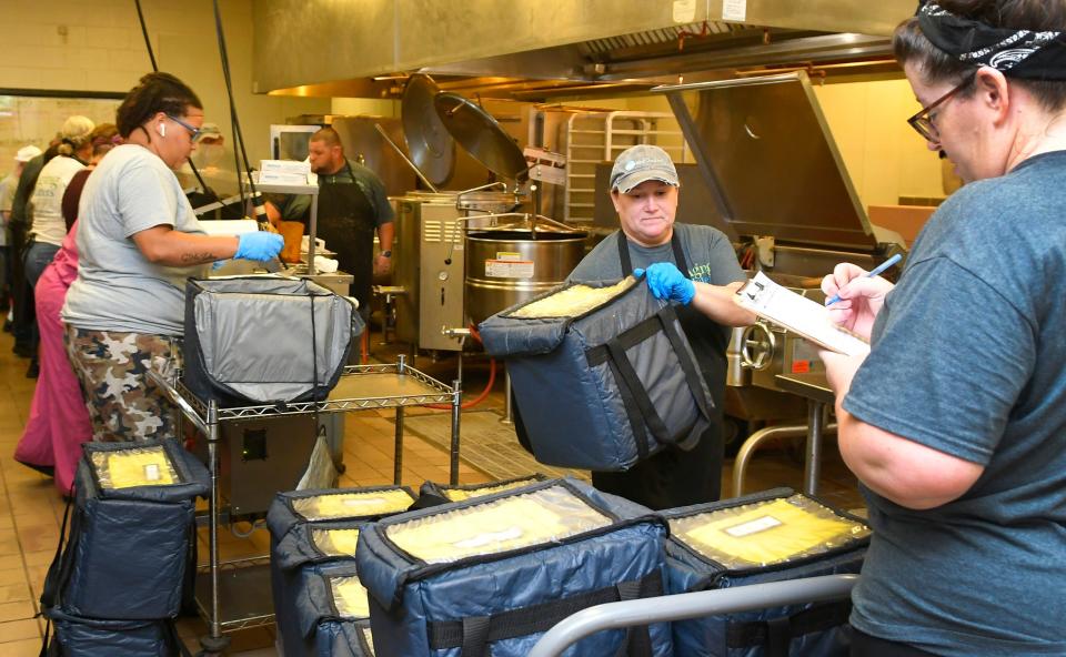 Workers prep food for delivery at the Community Kitchen on Rosa L. Jones Boulevard in Cocoa, where food for Meals on Wheels and Seniors at Lunch sites are prepared. Donors across the Space Coast recently stepped up to help Aging Matters in Brevard, which oversees meals programs, raise funds for a new 80-gallon kettle used every weekday in the kitchen.