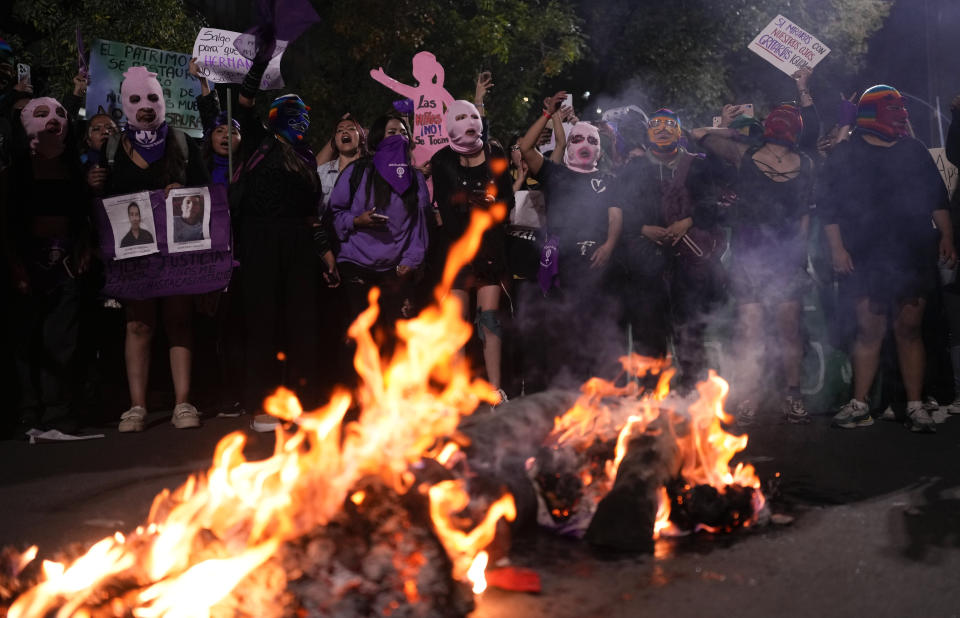 Manifestantes queman dos muñecos que representan a agresores y feminicidas durante la marcha por el Día Internacional de la Mujer en La Paz, Bolivia, el viernes 8 de marzo de 2024. (AP Foto/Juan Karita)