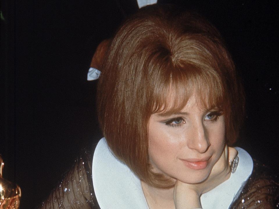 American singer and actor Barbra Streisand sits at a table with her Best Actress Oscar awarded for her role in director William Wyler's film, 'Funny Girl,' during the Academy Awards ceremonies, Los Angeles, California, April 14, 1969.