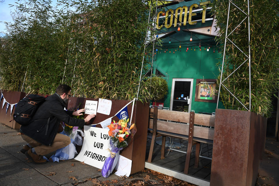 A man leaves a sign outside Comet Ping Pong saying: We Love Our Neighbors.