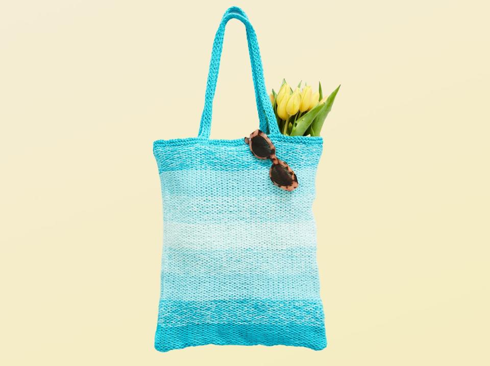 blue knitted tote bag with yellow flowers and sunglasses