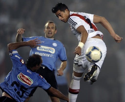 El atacante de River Plate Rogelio Funes Mori (D) intenta un taco frente a la marca del defensas de Belgrano Gaston Turus (I) durante un partido por la Liga argentina disputado en Buenos Aires el 05 de agosto de 2012. (AFP | alejandro pagni)