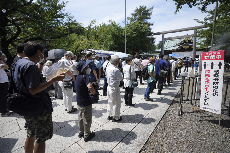 People queue to pay respects to the war dead at Yasukuni Shrine Monday, Aug. 15, 2022, in Tokyo. Japan marked the 77th anniversary of its World War II defeat Monday. (AP Photo/Eugene Hoshiko)