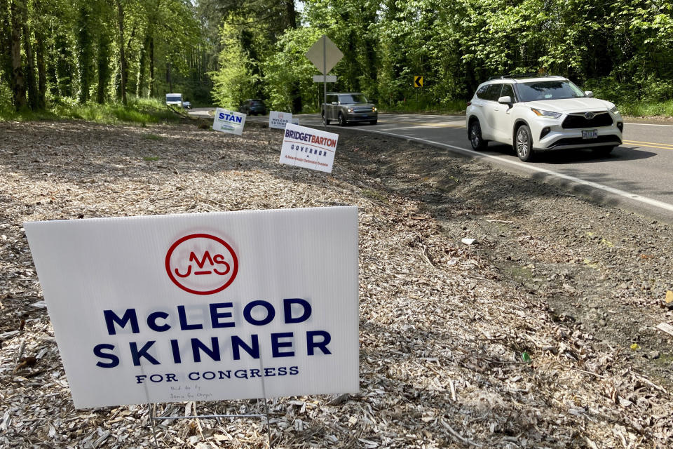 Cars navigate a busy street in Clackamas County, Oregon festooned with election signs for Congressional, Senate and governor's candidates on Tuesday, May 17, 2022. Clackamas County is home to Portland's southern suburbs and its rural-urban demographic mix is considered key in determining whether seven-term Democratic incumbent Rep. Kurt Schrader will survive a tough primary challenge from a progressive Democratic candidate, Jamie McLeod-Skinner. (AP Photo/Gillian Flaccus)