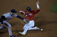 Boston Red Sox's Hunter Renfroe is safe at third past Houston Astros third baseman Alex Bregman on a wild throw during the second inning in Game 3 of baseball's American League Championship Series Monday, Oct. 18, 2021, in Boston. (AP Photo/Charles Krupa)