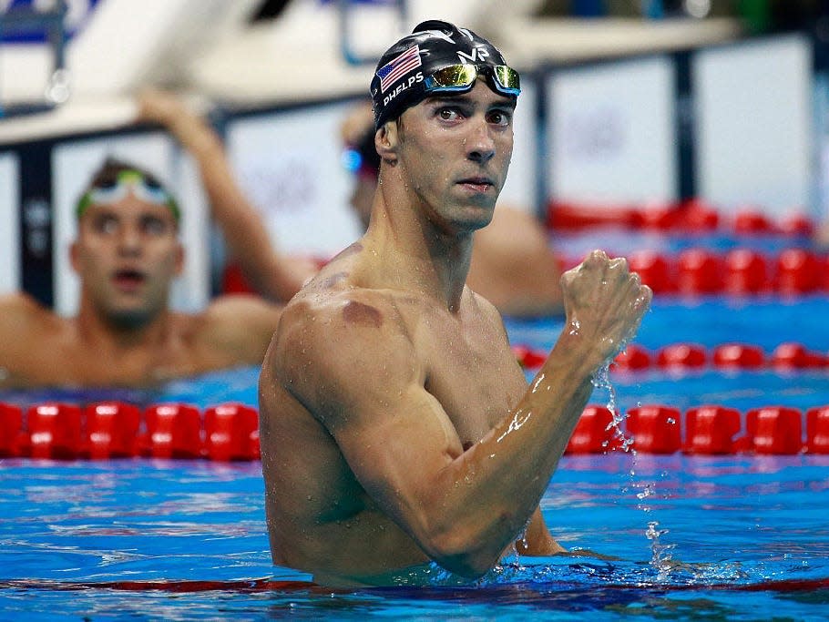 Olympic swimmer Michael Phelps in the pool celebrates with a fist pump after winning gold in the Men's 200m Butterfly Final on Day 4 of the Rio 2016 Olympic Games at the Olympic Aquatics Stadium on August 9, 2016 in Rio de Janeiro, Brazil