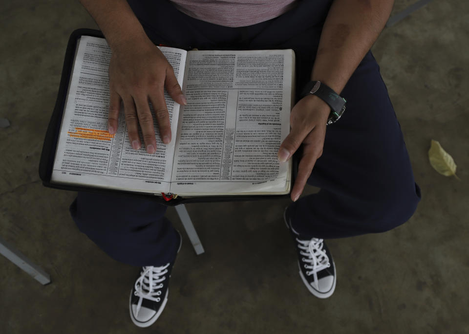 Un hombre joven que estuvo en prisión por formar parte de una pandilla lee la Biblia durante las horas de visitas familiares en el centro de rehabilitación "Vida Libre", en Santa Ana, El Salvador, el sábado 29 de abril de 2023. Vida Libre, un programa religioso fundado por el pastor estadounidense Kenton Moody, acoge a menores que está cerca de cumplir su sentencia de cárcel y han demostrado buena conducta. (AP Foto/Salvador Meléndez)