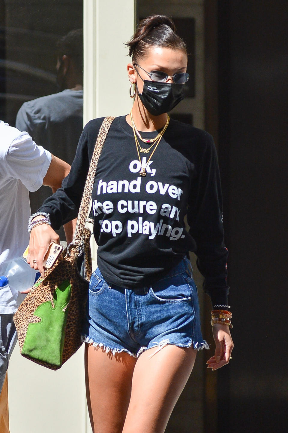 <p>Bella Hadid wears a statement shirt that says, "ok, hand over the cure and stop playing," in N.Y.C. on Thursday.</p>