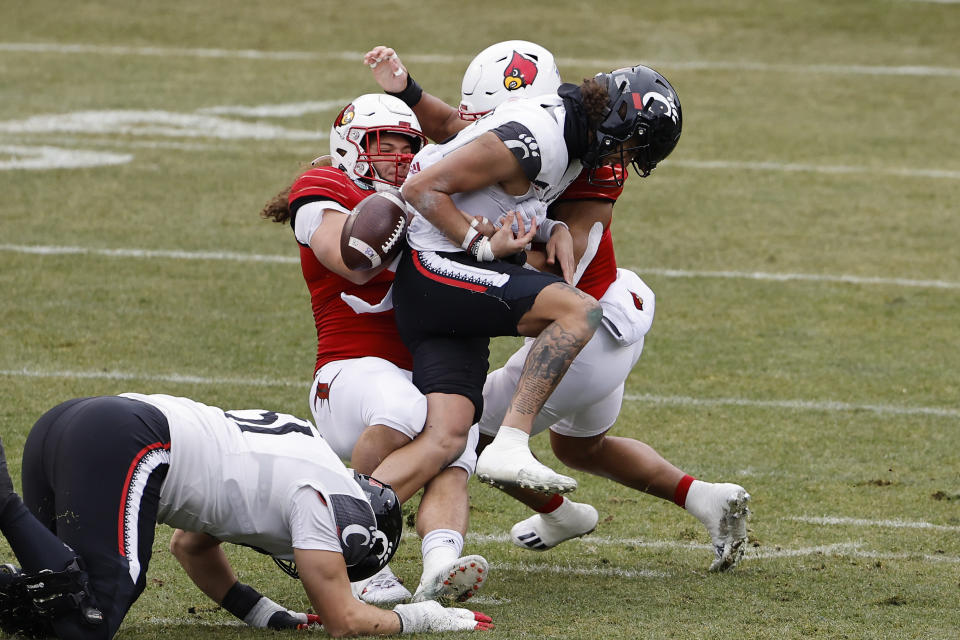 Cincinnati's Evan Prater fumbles as he is tackled by Louisville's Ashton Gillotte during the first quarter of the Fenway Bowl NCAA college football game at Fenway Park Saturday, Dec. 17, 2022, in Boston. (AP Photo/Winslow Townson)