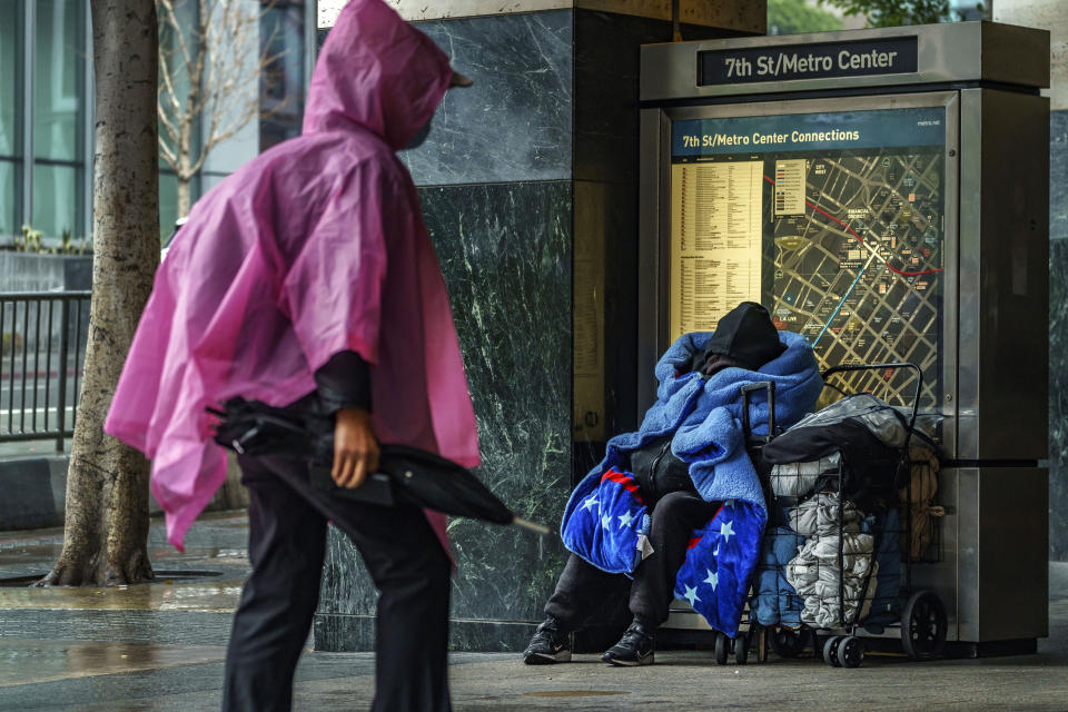 FILE - A homeless person covers up with a blanket outside the entrance to the 7th Street/Metro Center subway station in downtown Los Angeles on March 19, 2023. Democratic leaders in major U.S. cities are finding themselves politically squeezed when it comes to addressing homelessness. Some hope L.A.'s newly elected Mayor Karen Bass will make good on her campaign promise to move people out of tents and cardboard shanties and eventually into permanent housing. (AP Photo/Damian Dovarganes, File)