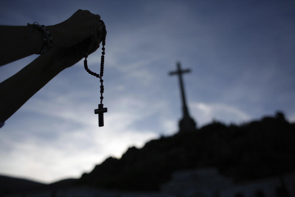 In this Thursday, Oct. 3, 2019 photo, a worshiper holds a rosary at the Valley of the Fallen mausoleum near El Escorial, outskirts of Madrid, Spain. After a tortuous judicial and public relations battle, Spain's Socialist government has announced that Gen. Francisco Franco's embalmed body will be relocated from a controversial shrine to a small public cemetery where the former dictator's remains will lie along his deceased wife. (AP Photo/Alfonso Ruiz)