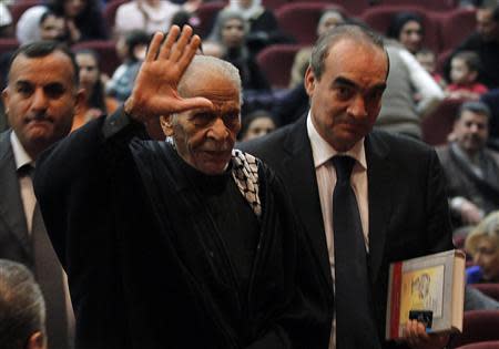 Egyptian poet Ahmed Fouad Negm (2nd R) waves upon his arrival to participate with the Palestinian folk Al Hanouneh troupe in Amman November 29, 2013. REUTERS/Muhammad Hamed