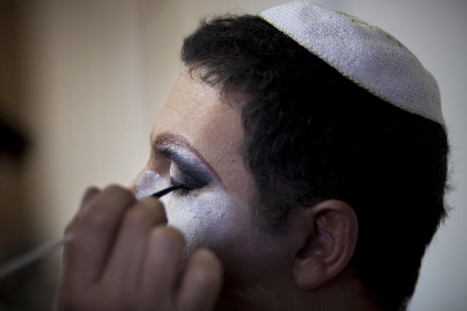 In this photo taken on Tuesday, June 18, 2013, Israeli Orthodox Jew Shahar Hadar has his makeup applied as he prepares for a show at a drag queen school in downtown Tel Aviv, Israel. Hadar, a telemarketer by day, has taken the gay Orthodox struggle from the synagogue to the stage, beginning to perform as one of Israel’s few religious drag queens. His drag persona is that of a rebbetzin, a female rabbinic advisor, a wholesome guise that stands out among the sarcastic and raunchy cast of characters on Israel’s drag queen circuit. (AP Photo/Oded Balilty)