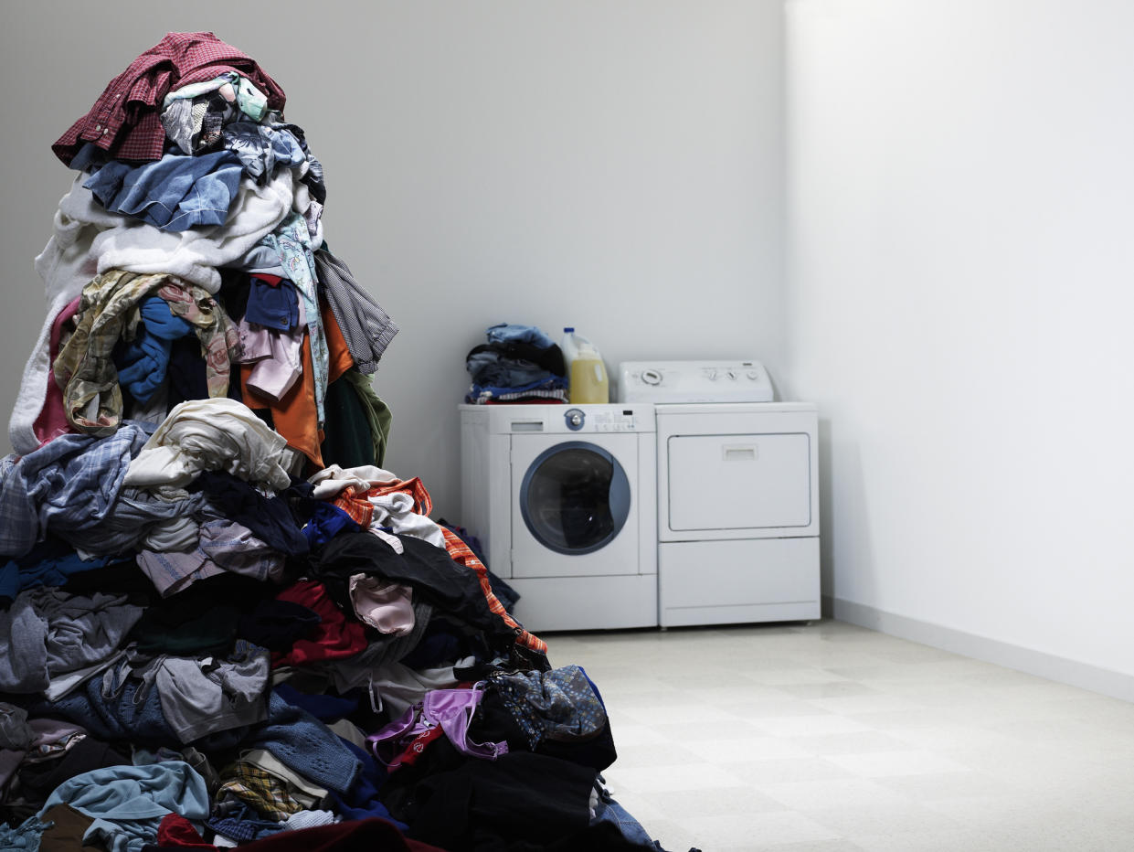 Laundry room with tall pile of clothes. (PHOTO: Getty Images)