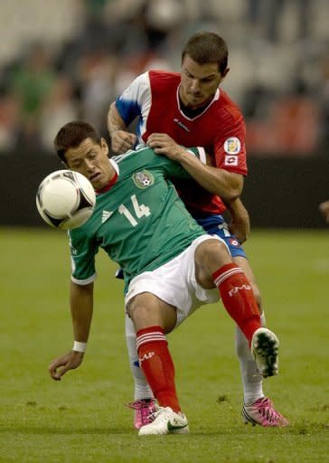 Costa Rica's Gabriel Badilla (R) and Mexico's Javier Hernandez fight for the ball during their World Cup CONCACAF qualifying match on September 11. Mexico have secured top spot in Group B with 12 points with two games left ahead of El Salvador on 5 points and Costa Rica on 4