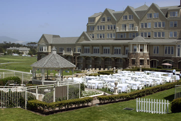 Outdoor wedding venue with gazebo and arranged chairs, overlooking a golf course. No persons visible