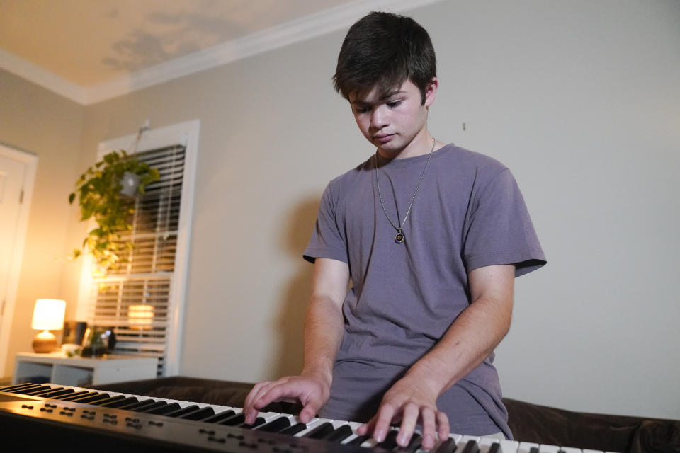 Callum Bradford plays a song on his electronic keyboard at his home, Thursday, Sept. 14, 2023, in Chapel Hill, N.C. Bradford, a transgender teen from Chapel Hill needed mental health care after overdosing on prescription drugs. He was about to be transferred to another hospital due to a significant bed shortage. A North Carolina hospital network is referring transgender psychiatric patients to treatment facilities that do not align with their gender identities. Though UNC Hospitals policy discourages the practice, administrators say a massive bed shortage is forcing them to make tough decisions. (AP Photo/Erik Verduzco)