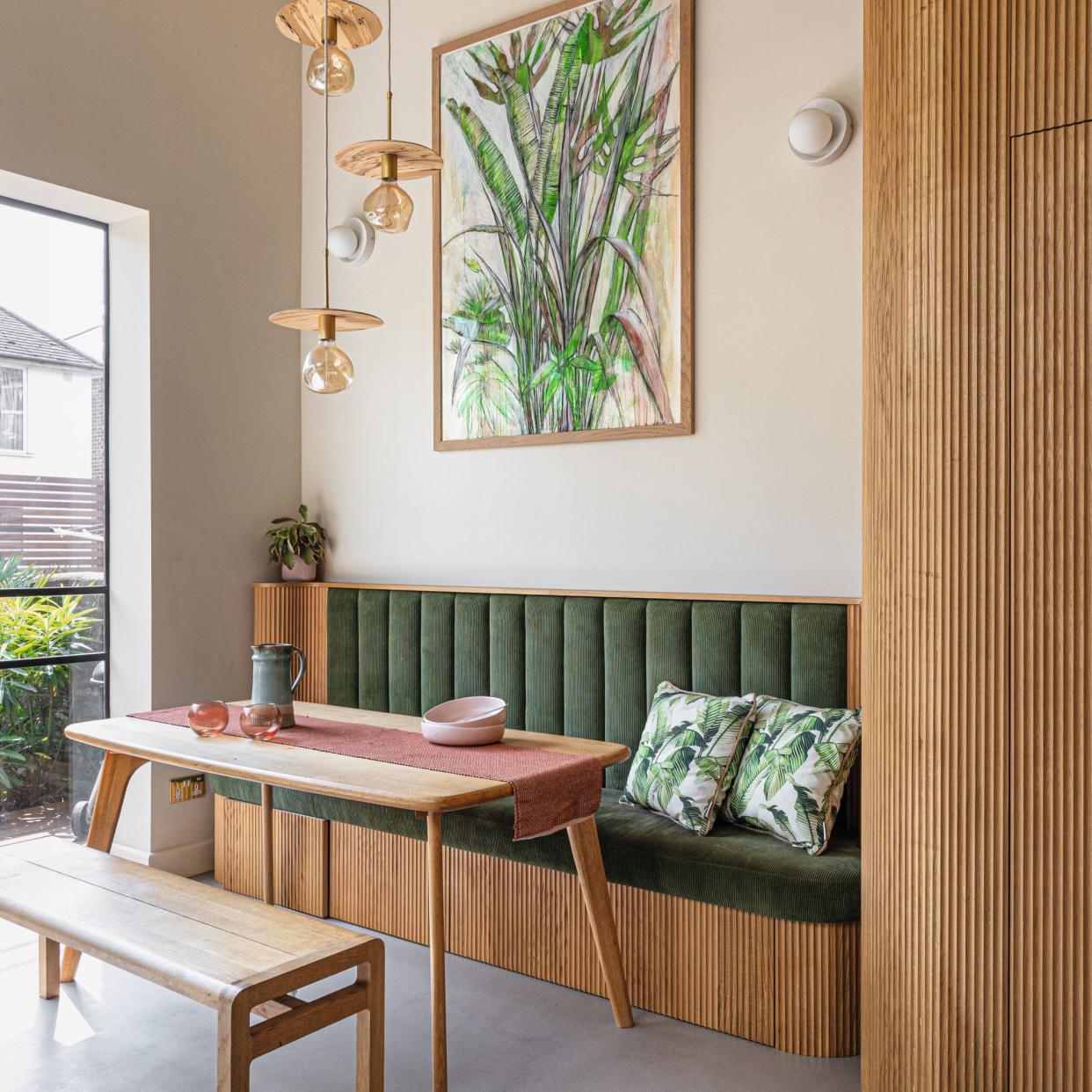  Green seating area, wooden dining table and artwork. 