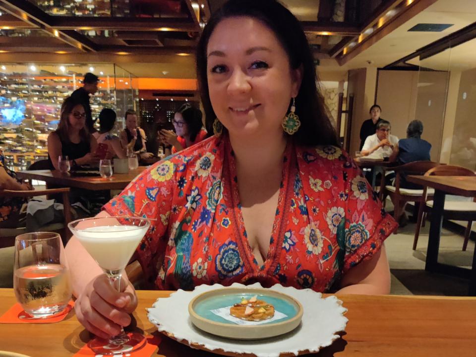 Author Sara Iannacone with a drink and small plate at a tasting dinner