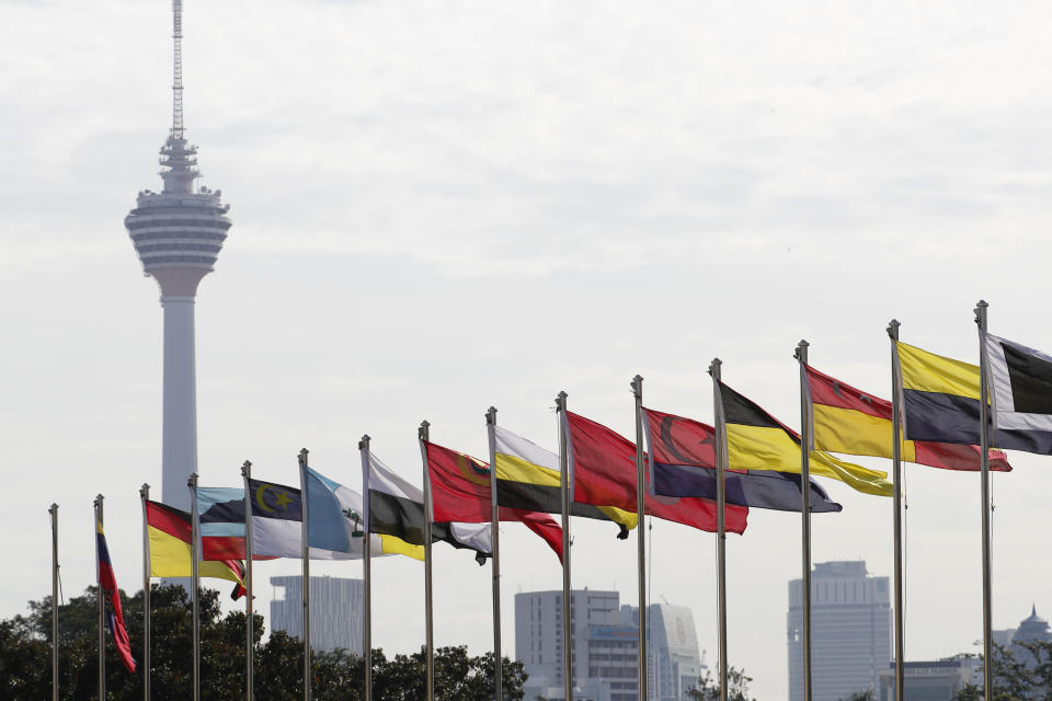 Kuala Lumpur Tower and flags of Malaysian states are seen during a welcome ceremony for King Sultan Abdullah Sultan Ahmad Shah at Parliament House in Kuala Lumpur, Malaysia, Thursday, Jan. 31, 2019. Sultan Abdullah, ruler of central Pahang state, was named Malaysia's new king, replacing Sultan Muhammad V who abdicated unexpectedly after just two years on the throne. (AP Photo/Vincent Thian)
