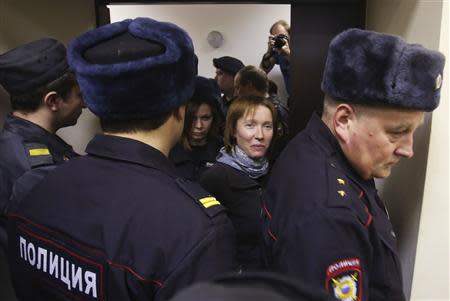 Yekaterina Zaspa (C), the"Arctic Sunrise" ship's doctor, and one of the 30 people arrested over a Greenpeace protest at the Prirazlomnaya oil rig, is escorted before a court session in St. Petersburg, November 18, 2013. REUTERS/Maxim Zmeyev