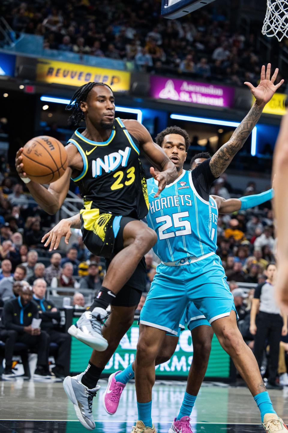 Dec 20, 2023; Indianapolis, Indiana, USA; Indiana Pacers forward Aaron Nesmith (23) passes the ball while Charlotte Hornets forward P.J. Washington (25) defends in the second half at Gainbridge Fieldhouse. Mandatory Credit: Trevor Ruszkowski-USA TODAY Sports