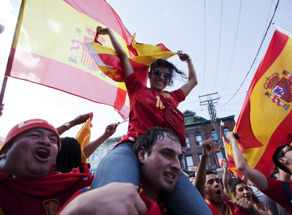 Spain soccer fan Pradeep Dads rides on Steven Uncu's back as they celebrate their teams win against Italy in the Euro 2012 soccer championship final in Kiev, Ukraine. Toronto, Sunday, July 1, 2012. THE CANADIAN PRESS/Michelle Siu