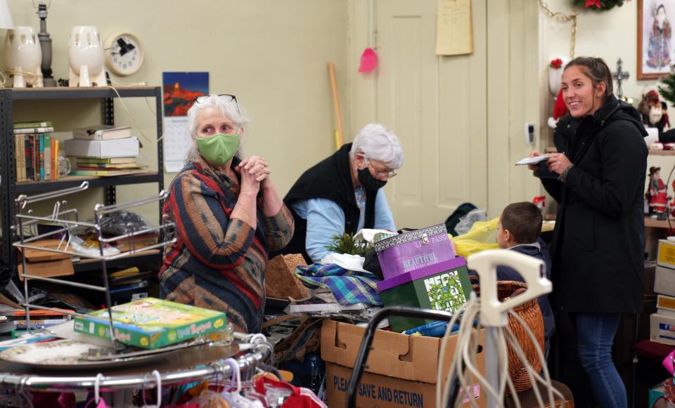 Sharon DuBois, in the green mask, chats with an unmasked customer in thrift shop she runs, after her mother passed away from COVID-19 at the nursing home at the Gove County Medical Center.