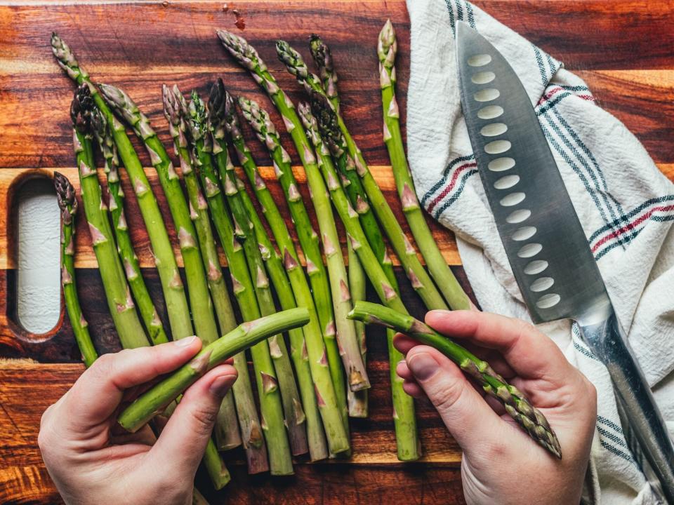 two hands show asparagus spears snapped in half
